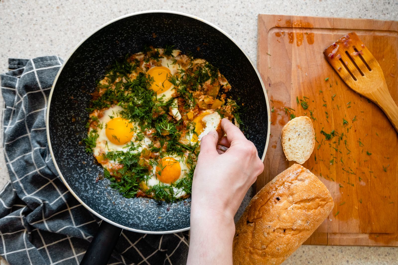 Shakshuka in der Pfanne, daneben Brot